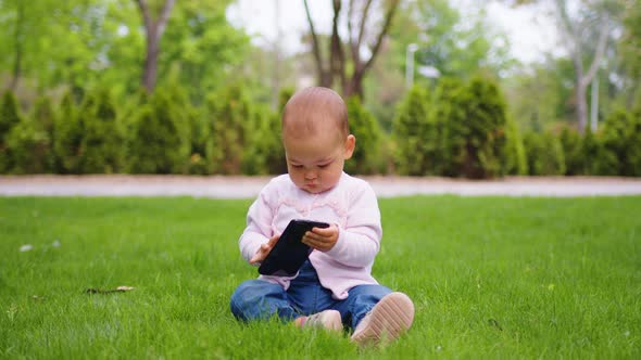 Baby Girl Concentrating on Her Phone at the Park