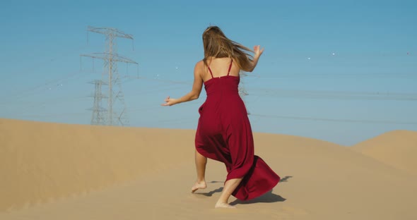 Sexy Woman in Red Dress is Dancing in the Desert Posing Rub Al Khali