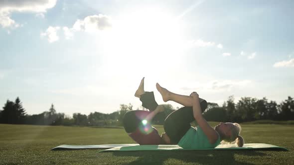 Pilates Women Doing Rolling Like a Ball Exercise