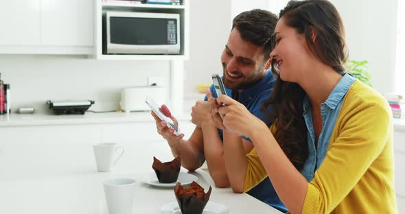 Couple interacting with each other while using mobile phone