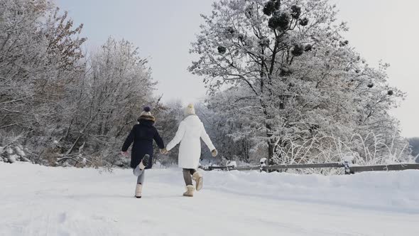 Mom and Daughter Play in Nature in Winter