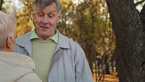 Caucasian Elderly Middleaged Woman Grandma Meet Embracing Senior Husband Pensioner Grandpa in Autumn