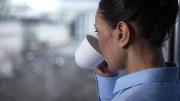 Smiling Face of Woman Drinking Coffee By Window