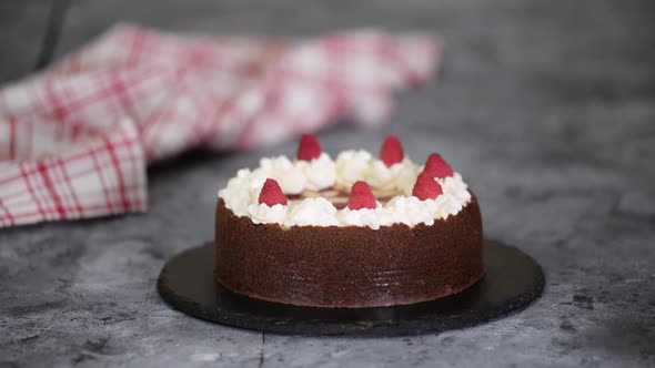 Chef Decorating a Cheesecake with Raspberries.