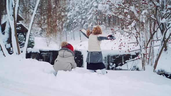 Children play outdoors in snow. Outdoor fun for family Christmas vacation.