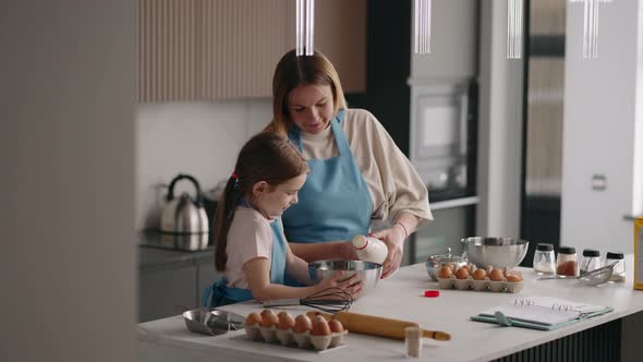 Family in Kitchen in Sunday Morning Mother and Little Daughter are Cooking Omelette with Eggs