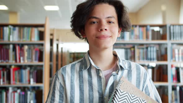 Slow Motion Portrait of Joyful Teenager Standing in School Library with Books