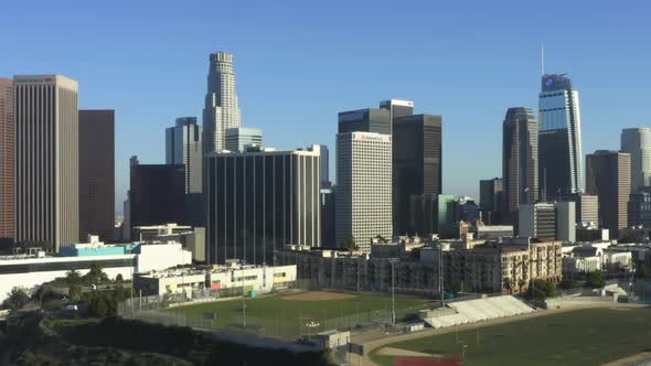 AERIAL: Flying Towards Downtown Los Angeles, California Skyline with Sports Football Baseball and