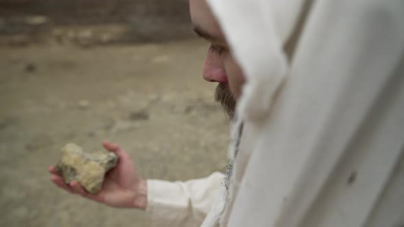 Jesus Or Biblical Man Picks Up Stone