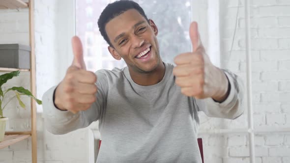 Portrait of AfroAmerican Man Gesturing Thumbs Up Indoor