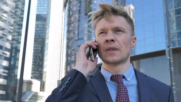Walking Businessman in Suit Talking on Phone