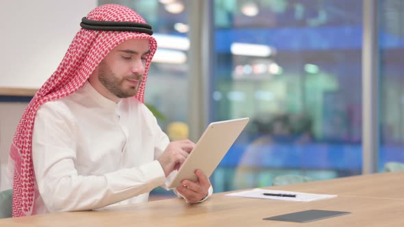 Serious Professional Arab Businessman Using Tablet in Office 