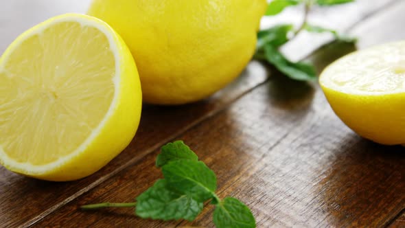 Full and half lemons with mint leaf on table