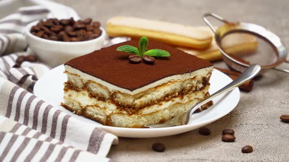 Portion of Traditional Italian Tiramisu dessert on grey concrete background