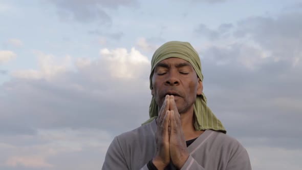 black man praying to god Caribbean man praying with blue sky in the background stock video