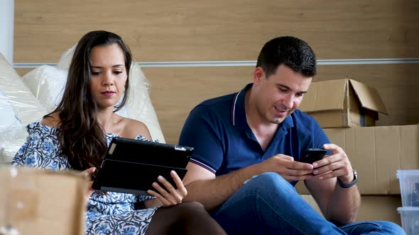 Young Couple in New Home Surrouned By Boxes