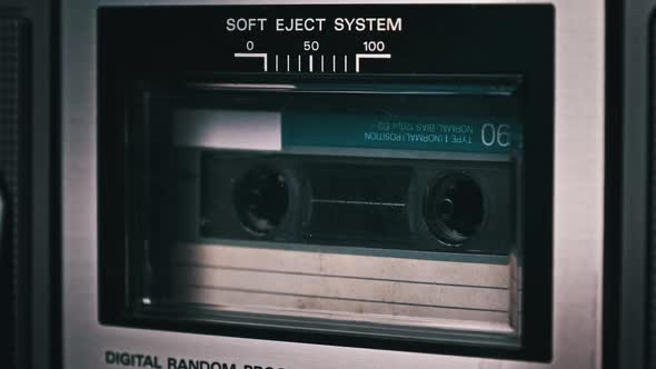 Audio Cassette Rotates in Deck of an Old Tape Recorder