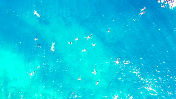 Luxury overhead tourism shot of a sunshine white sandy paradise beach and aqua blue water background
