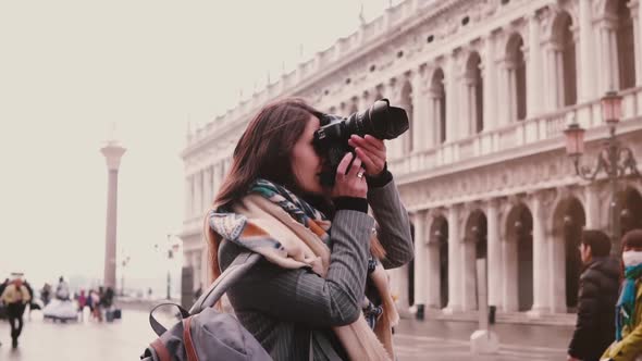 Beautiful Female Travel Blogger with Camera Taking Photos of St Mark Buildings in Venice Italy