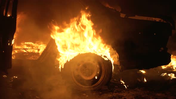 Burning car body, burning iron, broken car on fire