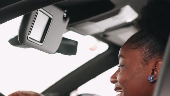 African American Woman Choosing a Car in a Salon and Checking the Salon