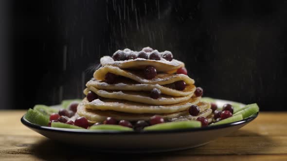Pancakes Pile on Plate Dusted with Powdered Sugar