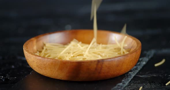 On a Wooden Plate of Pasta Falls the Dry Pasta Vermicelli. 