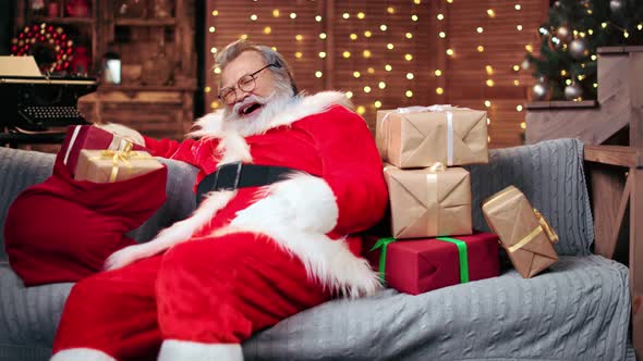 Tired Male in Santa Claus Costume Asleep at Christmas Eve Night