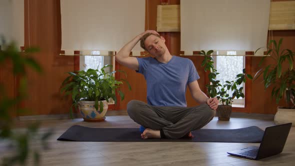 Goodlooking Man Watching Online Training and Stretching Muscles of Neck and Head