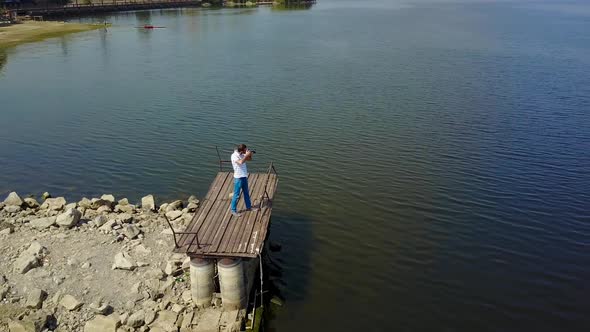 Male Photographer Near The Lake. Profesisonal photographer taking shot of beautiful nature near lake