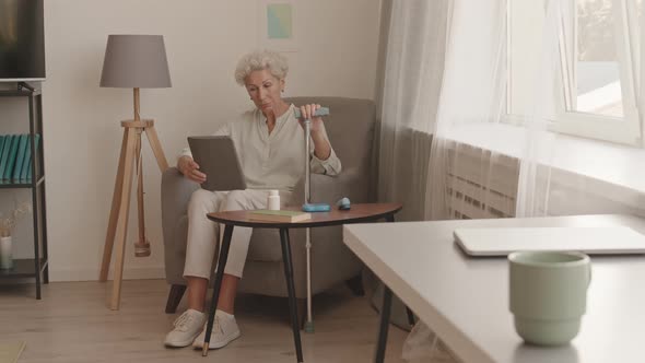 Senior Woman with Walking Stick Video Chatting on Tablet