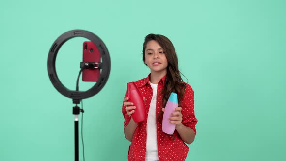 Smiling Child Beauty Blogger and Adviser Choosing Between Body Lotion and Shower Gel Video Blog