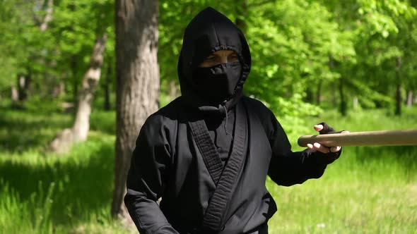 Portrait of a Ninja Man. Japanese Ninja in a Black Suit Is Training in Nature