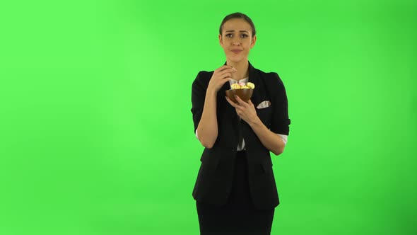 Unhappy Girl with Great Pleasure Eats a Multi-colored Candy. Green Screen