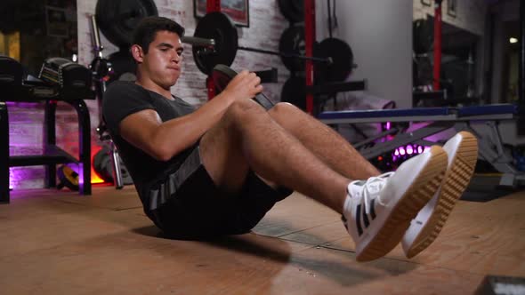 Young Man Performing Abdominal Exercises with Weights alt