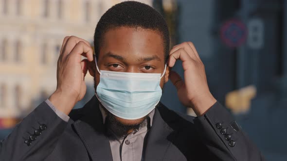 Headshot Portrait African American Businessman Puts on Protective Medical Mask Standing Outdoor