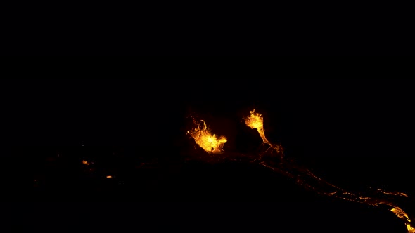 Aerial drone view of the Fagradalsfjall volcano erupting at night.