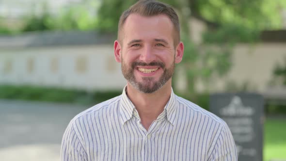 Outdoor Portrait of Middle Aged Man Smiling at Camera