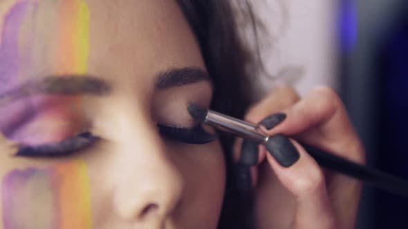 Closeup View of Makeup Artist Makes Models Eye Makeup with False Eyelashes