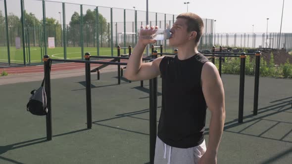 Sportsman Drinking Water At Outdoor Workout