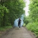 Young Male with Face Mask in Sportswear Running with Blues Smoke Bomb on the Road at Forest. Men - VideoHive Item for Sale