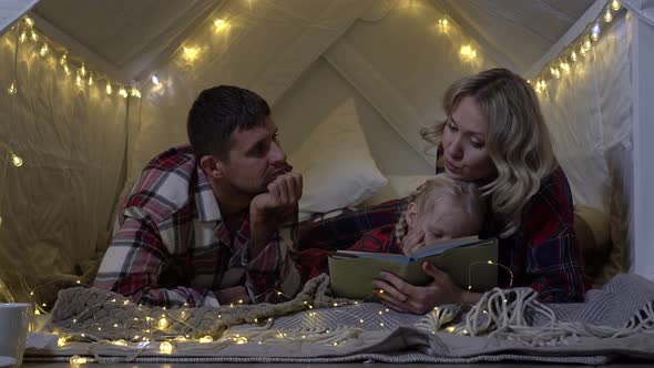 At Christmas Parents Read a Bedtime Story to Their Child