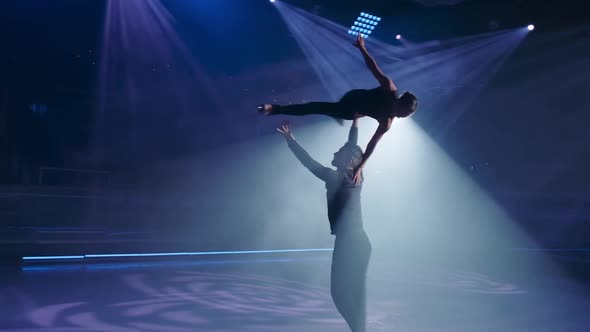 Figure Skaters Perform Stationary Rotational Overhead Lift