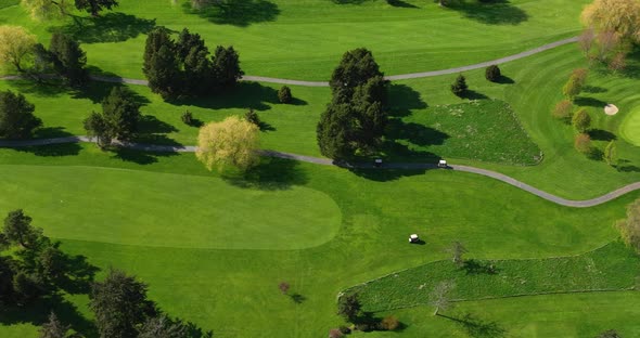 Drone shot of golfers in golf carts seeking out where their golf balls landed.