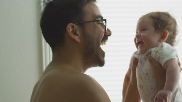Slow Motion of Dad Lifting Baby While They Both Laugh
