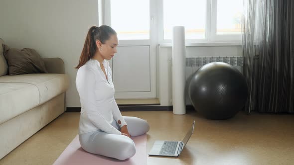 Girl Watches Video of Training on Laptop Sitting on Floor