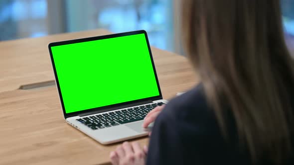 Rear View of Businesswoman using Laptop with Green Chroma Key Screen 