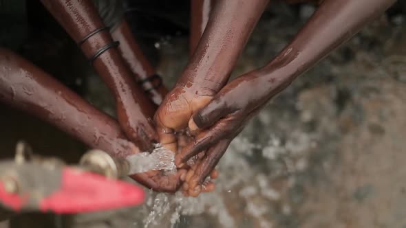 African Children Wash Hands under a water tap.