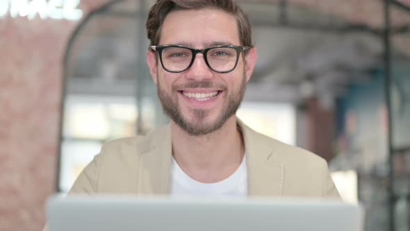 Close Up of Man with Laptop Smiling at Camera