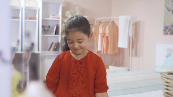 Little girl looking in the mirror and smiling.